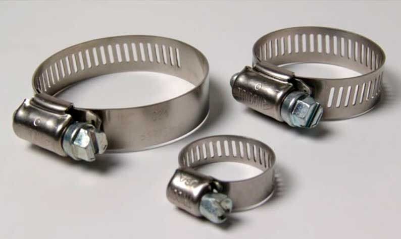 Tres abrazaderas de manguera de acero inoxidable se encuentran sobre una superficie blanca.