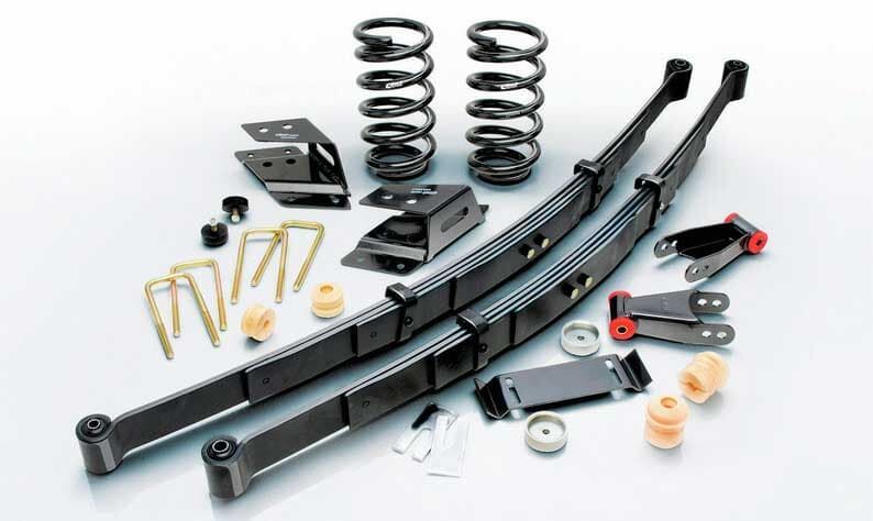 Un montón de resortes y ballestas sobre una superficie blanca.