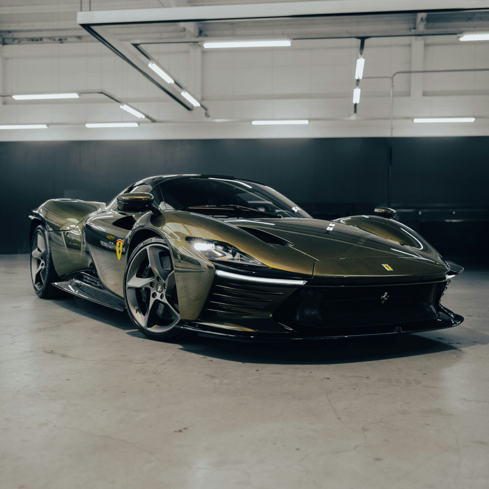 Red Ferrari sports car in a bright white room, front view.