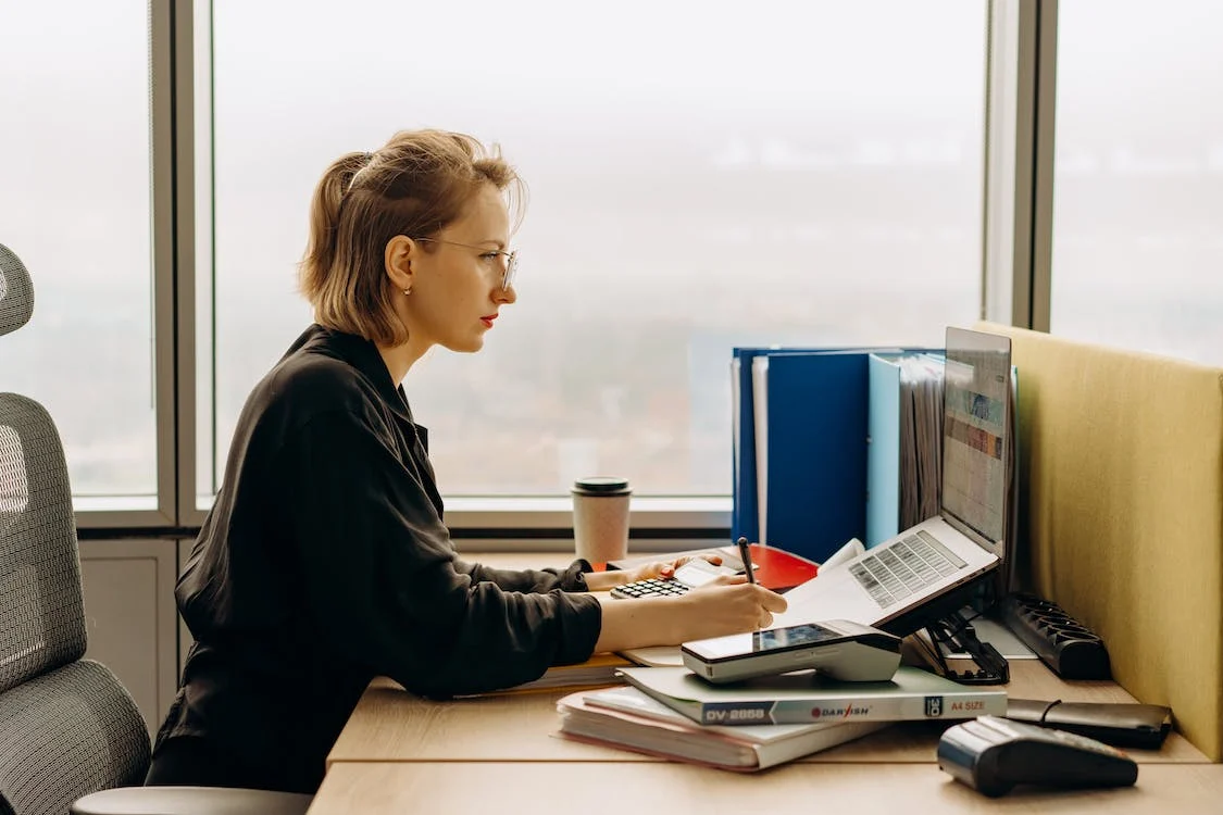 Une femme portant des lunettes travaille à un bureau 