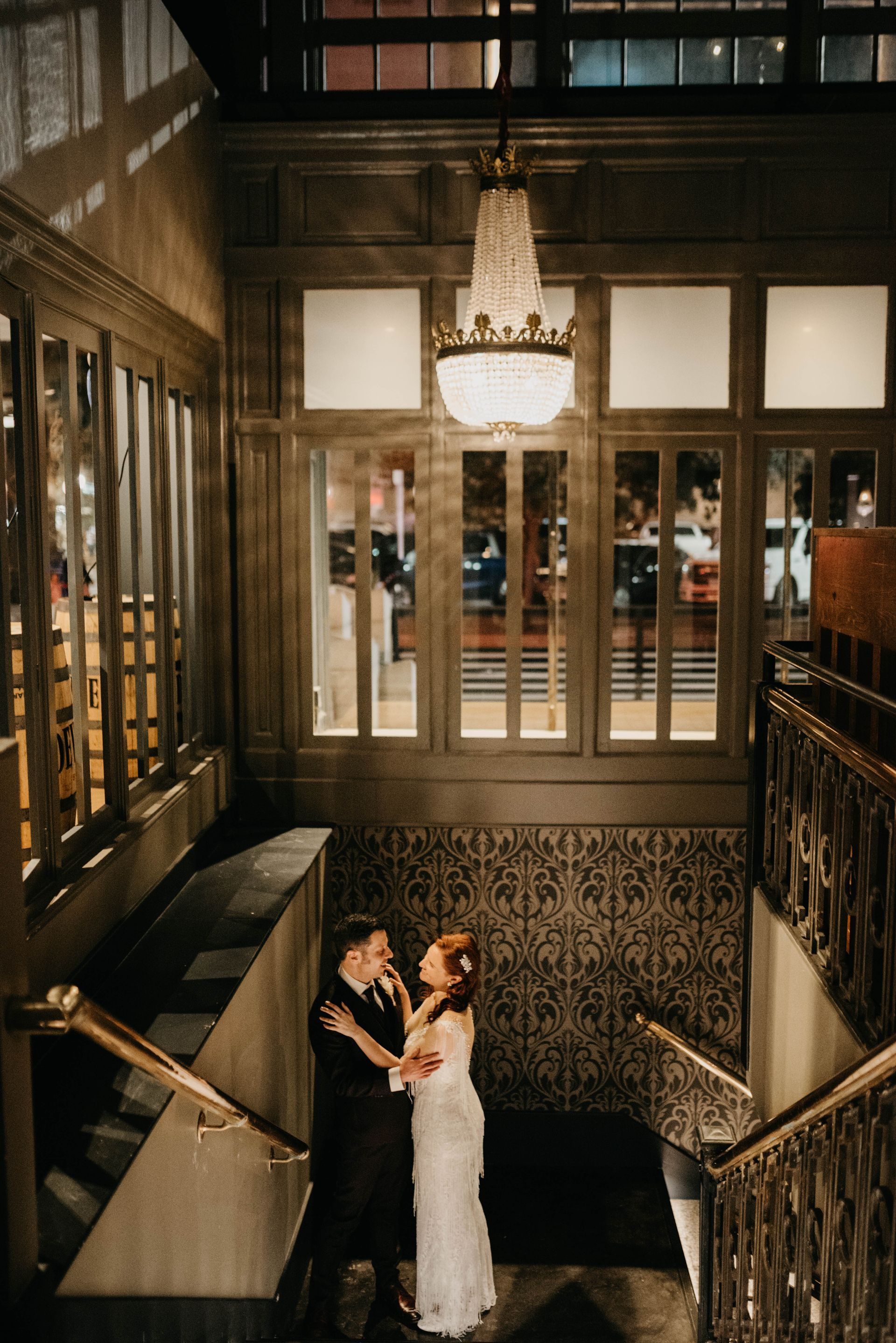 a bride and groom kiss on the stairs of a building