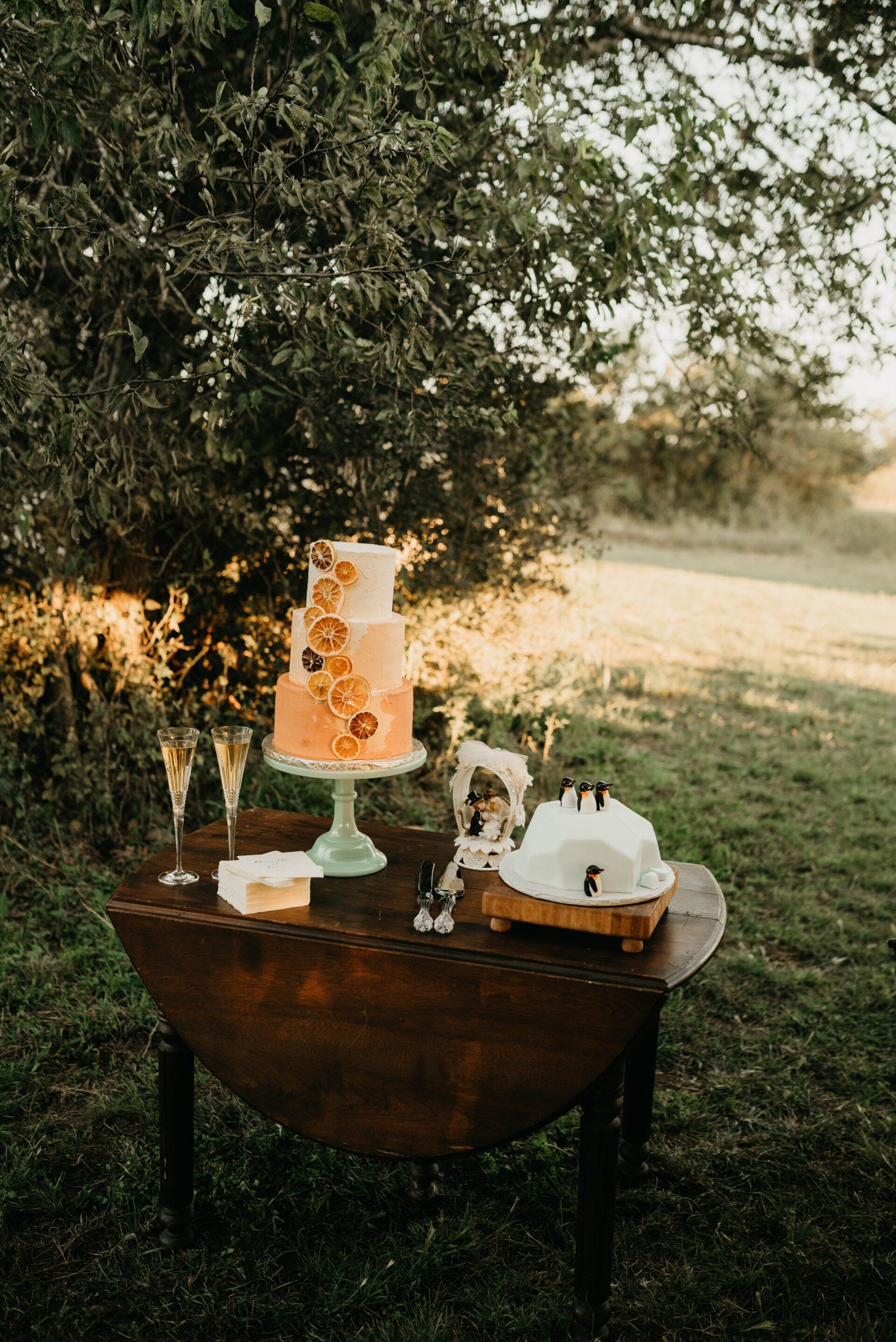 a table with a cake and two glasses of champagne on it