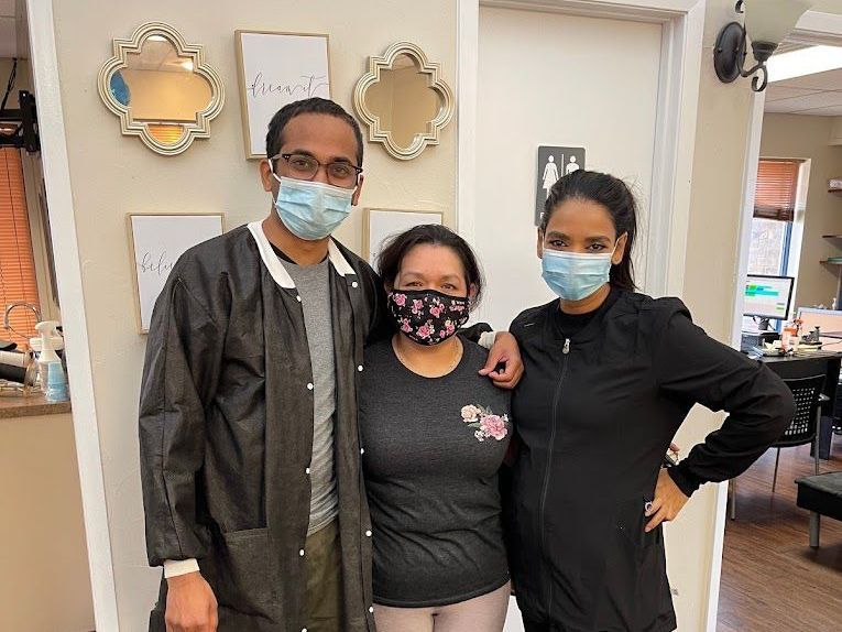 A man and two women wearing face masks are posing for a picture.