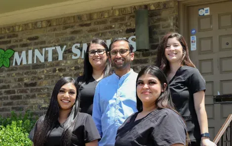 A group of people are posing for a picture in front of a building.