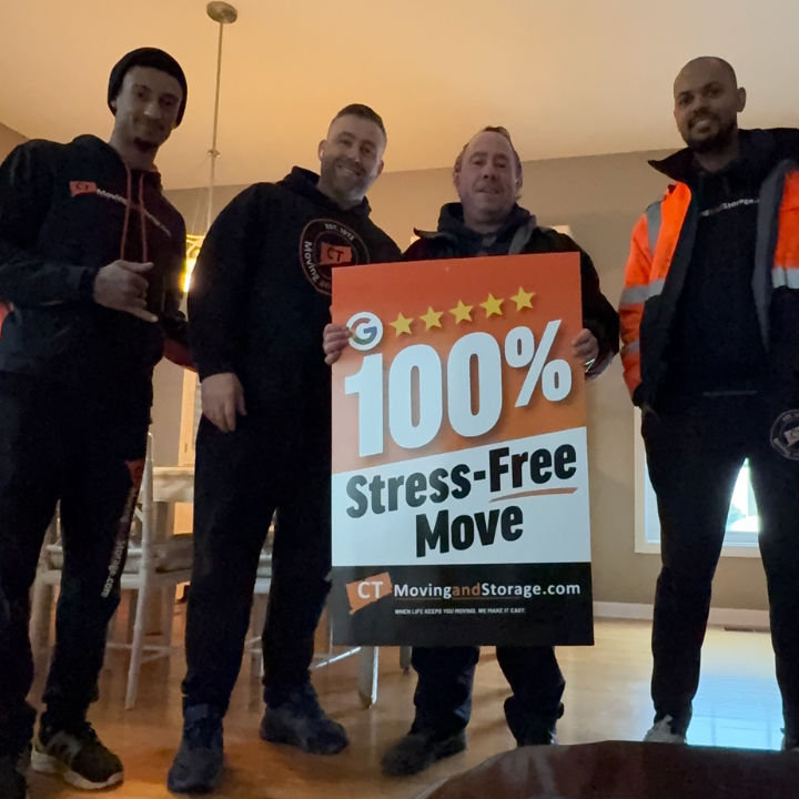 Four movers holding a sign that says