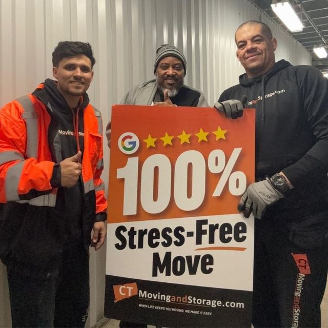 Three people hold a sign that reads 