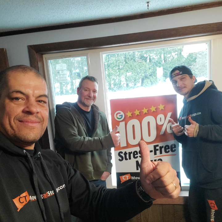 Three men with thumbs up, next to sign. Sign reads