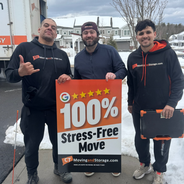 Three men pose with a sign that reads 
