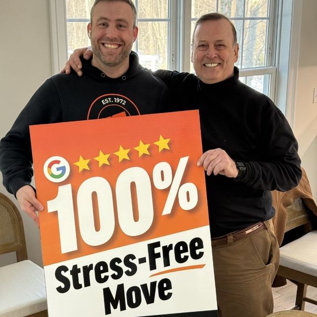 Two men holding a sign that says 