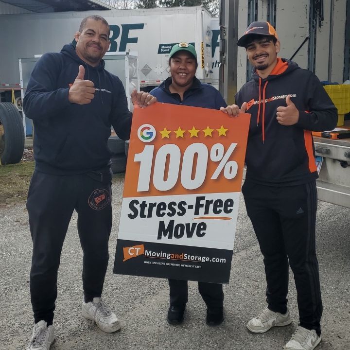 Three movers holding a bright orange 