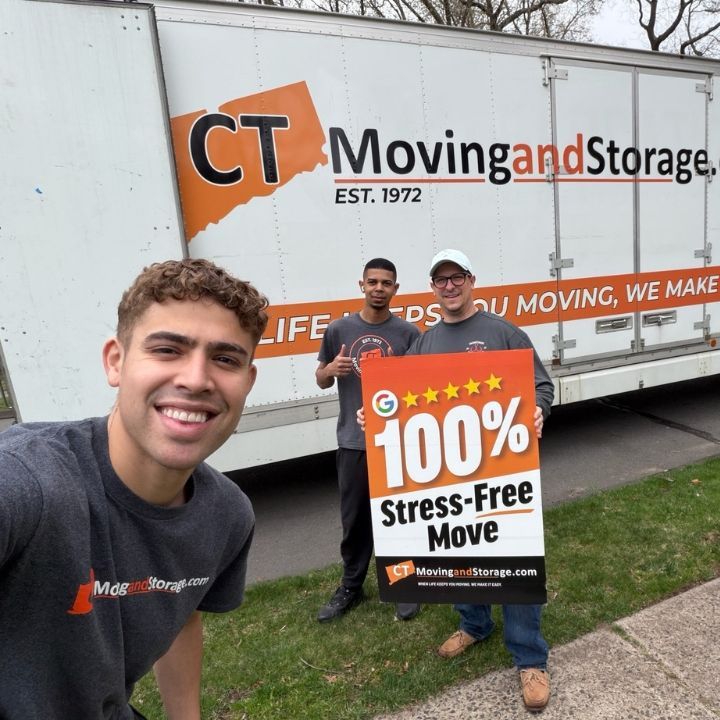 Three men posing with a 100% stress-free move sign in front of a CT Moving and Storage truck