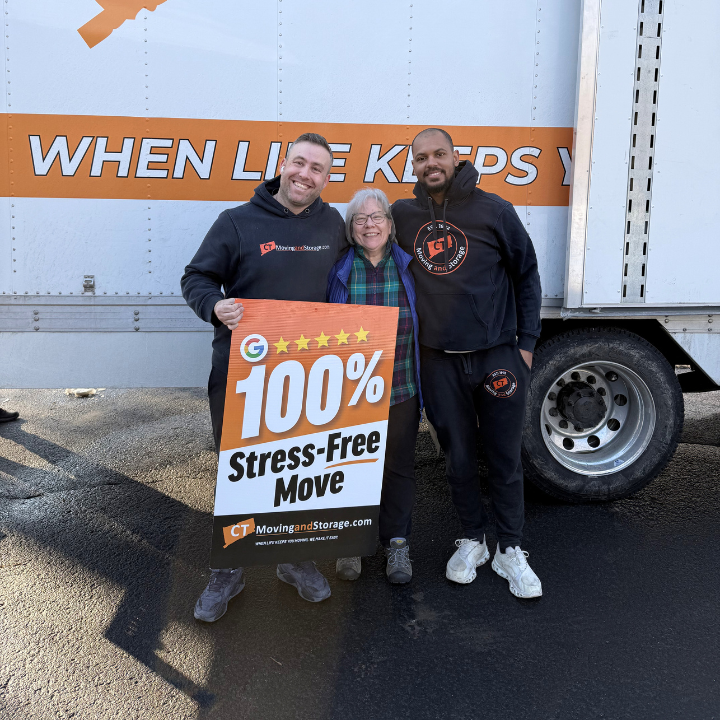 Three people stand with a sign that reads