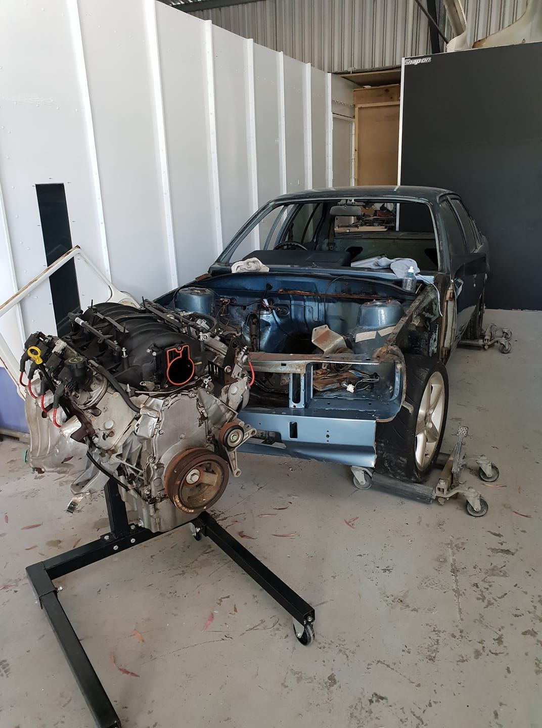 The Engine Of A Car Is Sitting On A Stand In A Garage — East Coast Panel & Paint In Woolgoolga, NSW