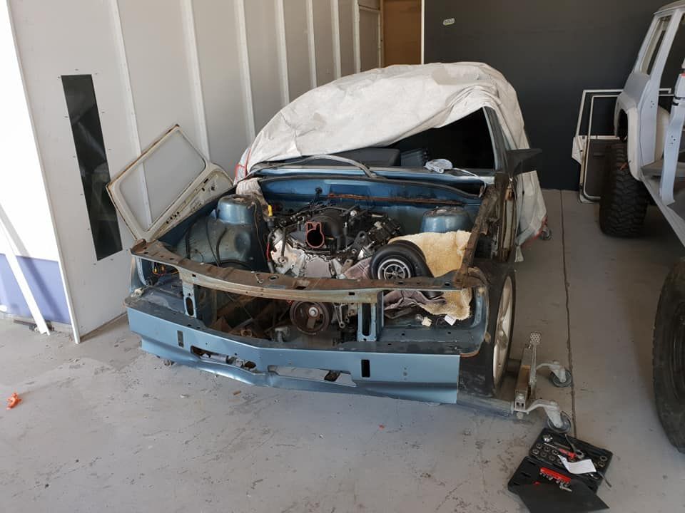 A Blue Car With The Hood Open Is Sitting In A Garage — East Coast Panel & Paint In Woolgoolga, NSW