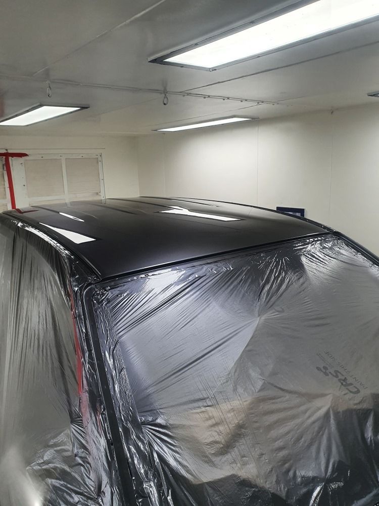 A Car Is Covered In Plastic Wrap In A Garage — East Coast Panel & Paint In Woolgoolga, NSW