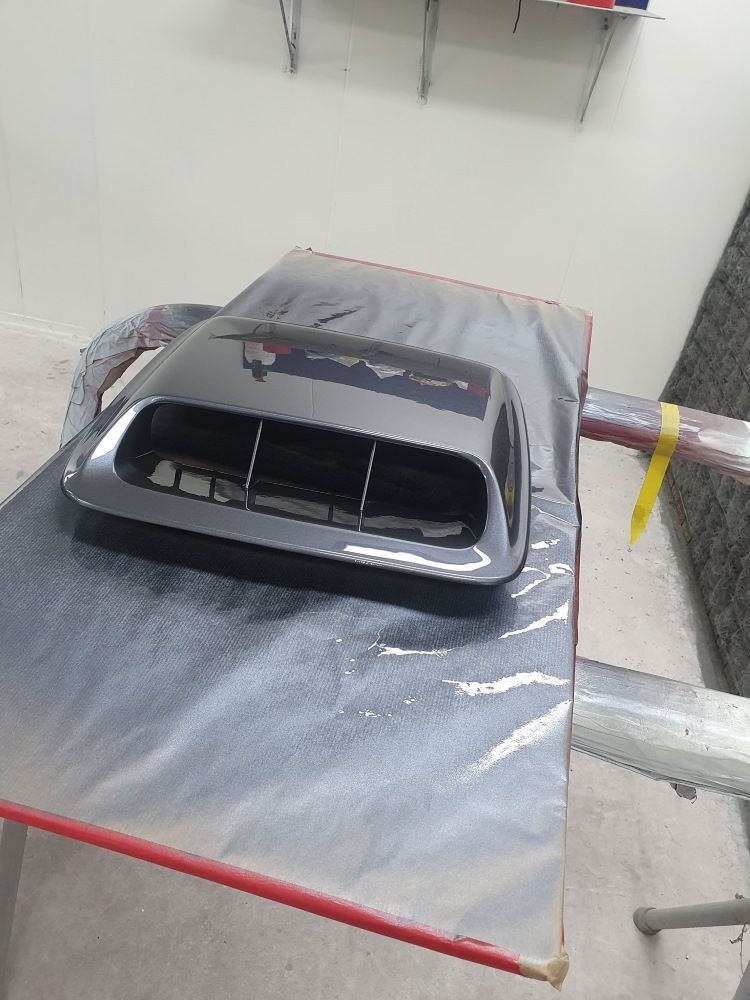 A Black Hood Scoop Is Sitting On Top Of A Table Covered In Plastic — East Coast Panel & Paint In Woolgoolga, NSW