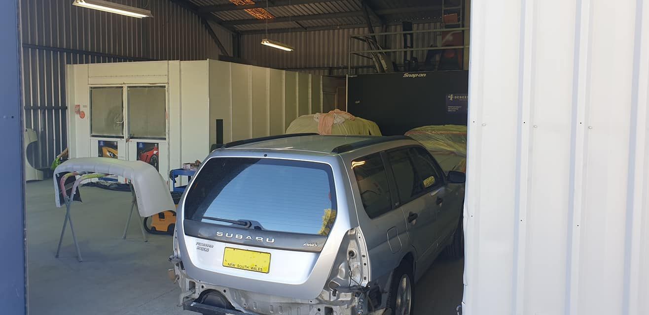 A Car Is Being Painted In A Garage — East Coast Panel & Paint In Woolgoolga, NSW