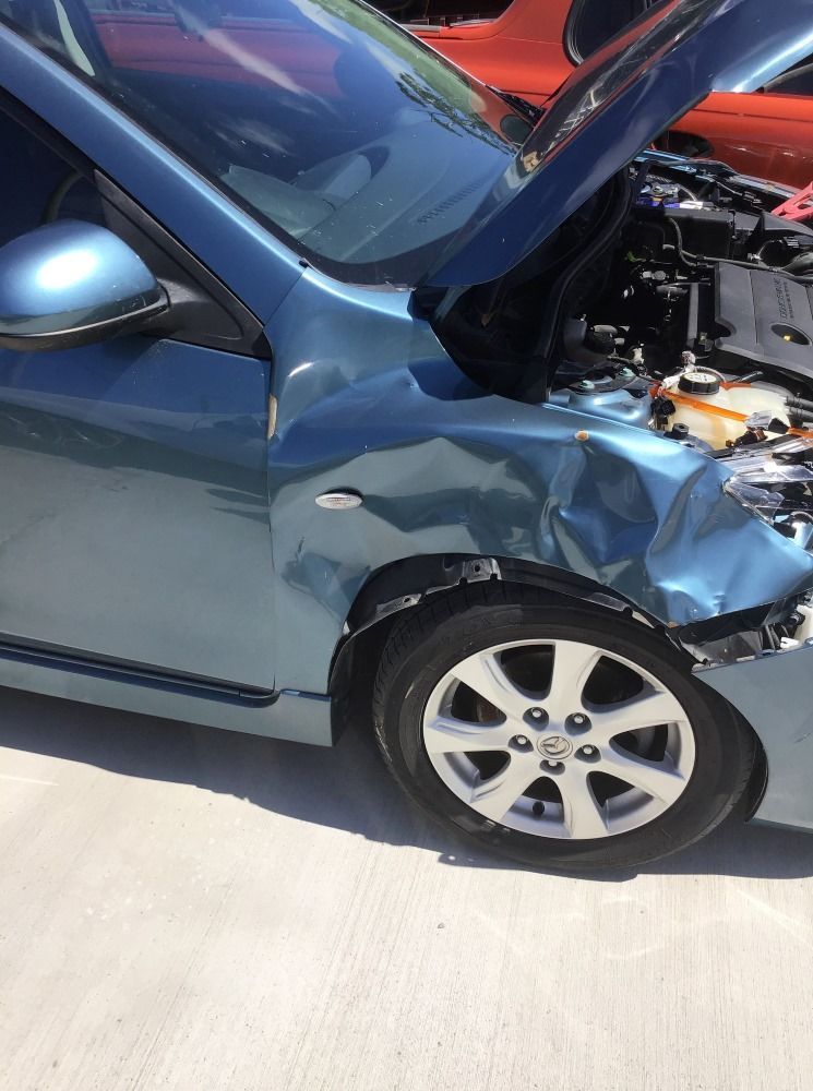 A Blue Car With Its Hood Open Is Parked On The Side Of The Road — East Coast Panel & Paint In Woolgoolga, NSW