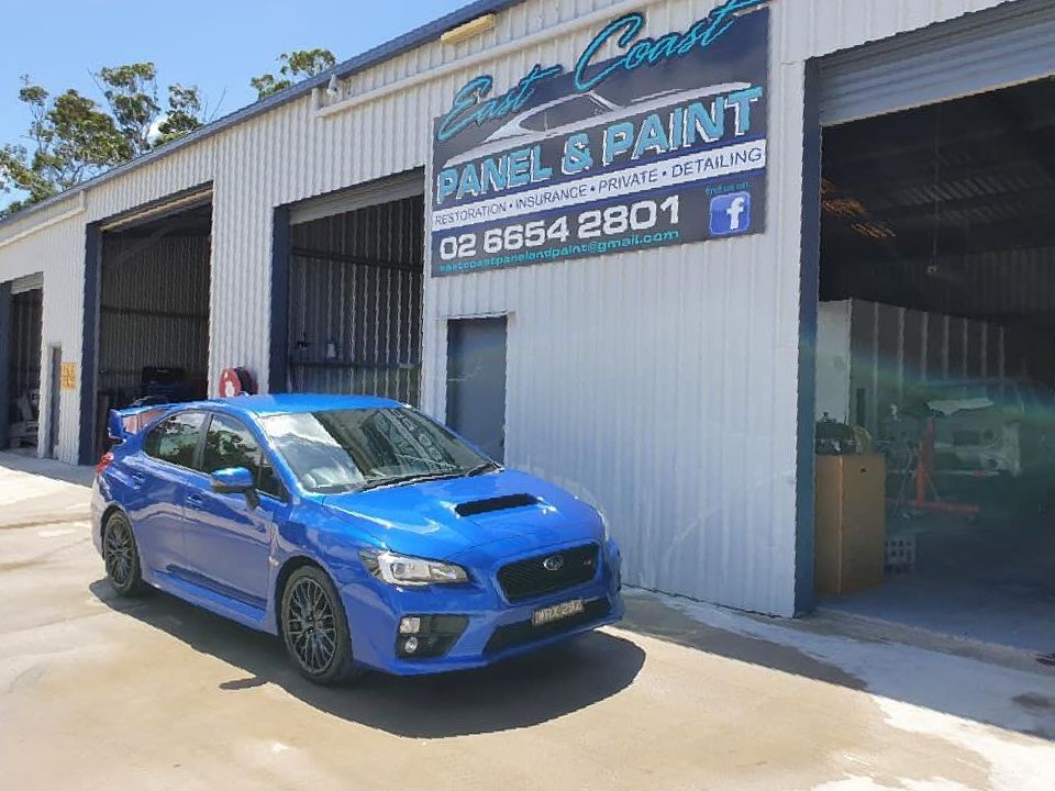 A Blue Car Is Parked In Front Of A Building — East Coast Panel & Paint In Woolgoolga, NSW