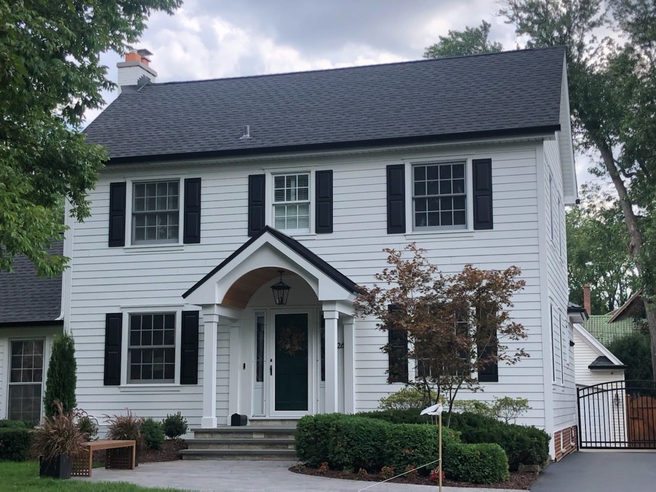 A white house with black shutters and a black roof