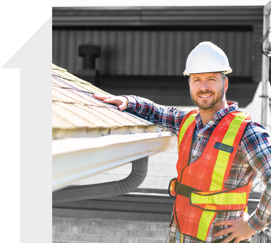 A roofing contractor is smiling next to a roof he recently installed.