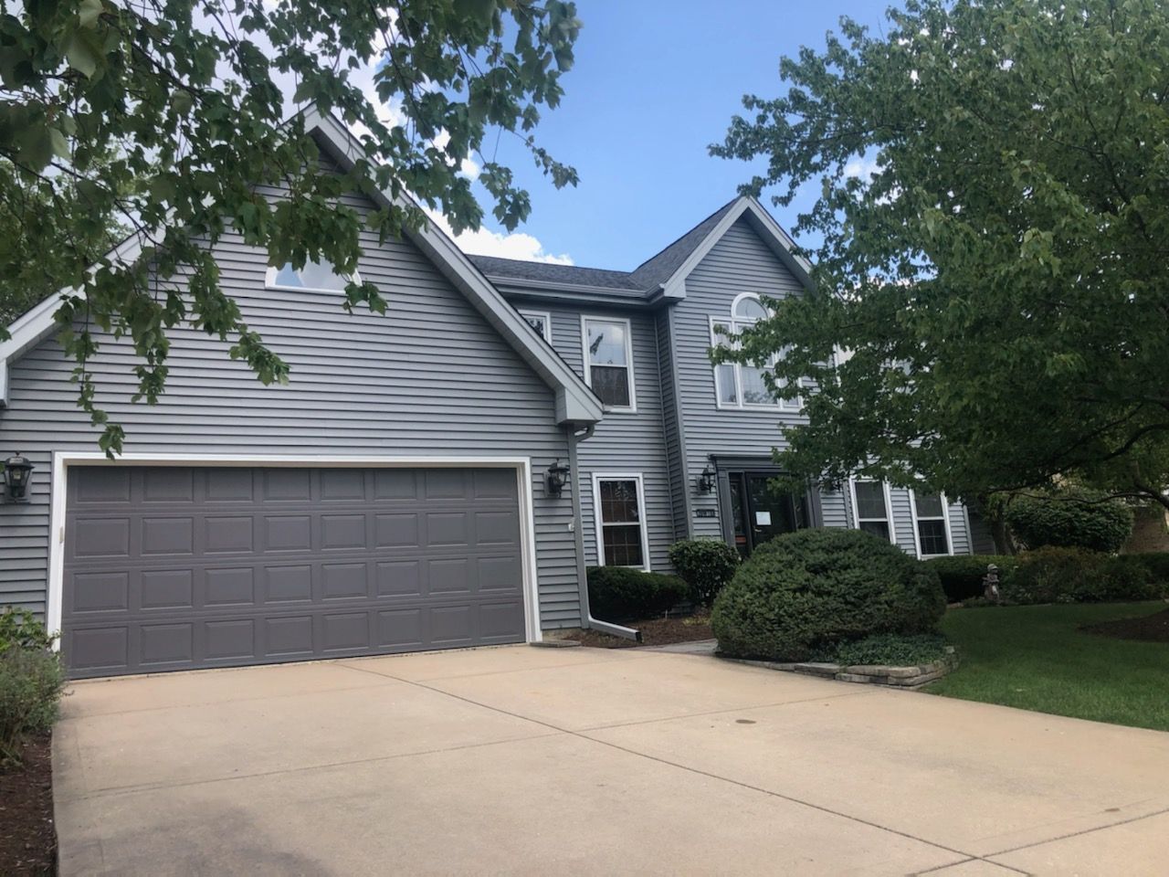 A large house with a garage and a driveway in front of it.