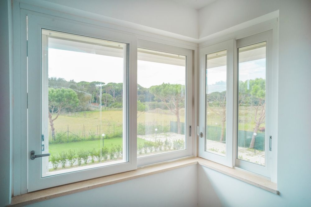 Brick house exterior with dark metal roof, oval windows, and chimney.
