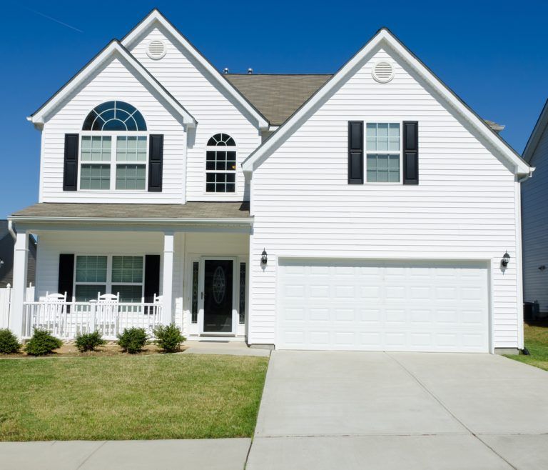 A white house with black shutters and a white garage door