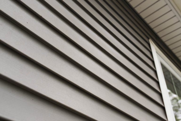 A close up of a siding on a house with a window