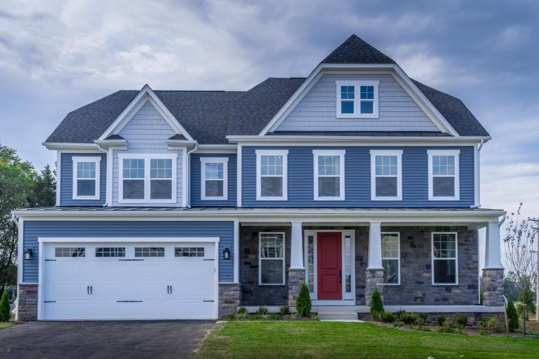 A blue house with white trim and a red door