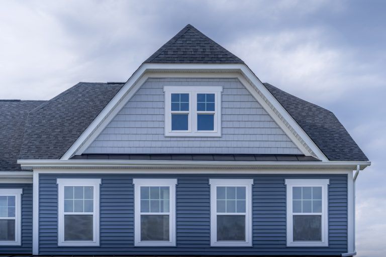 A blue house with white trim and a gray roof