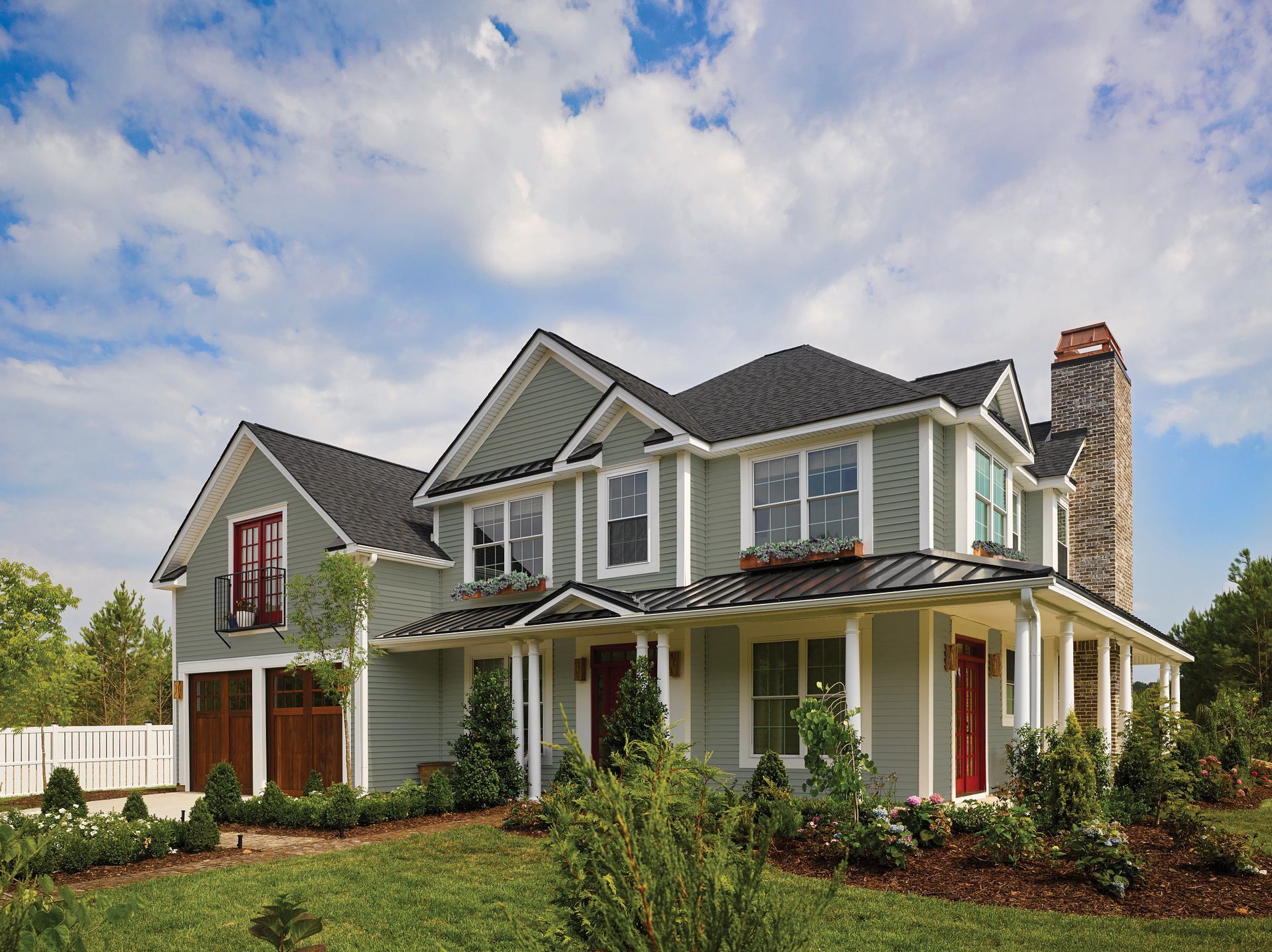 A large house with a gray siding and a black roof