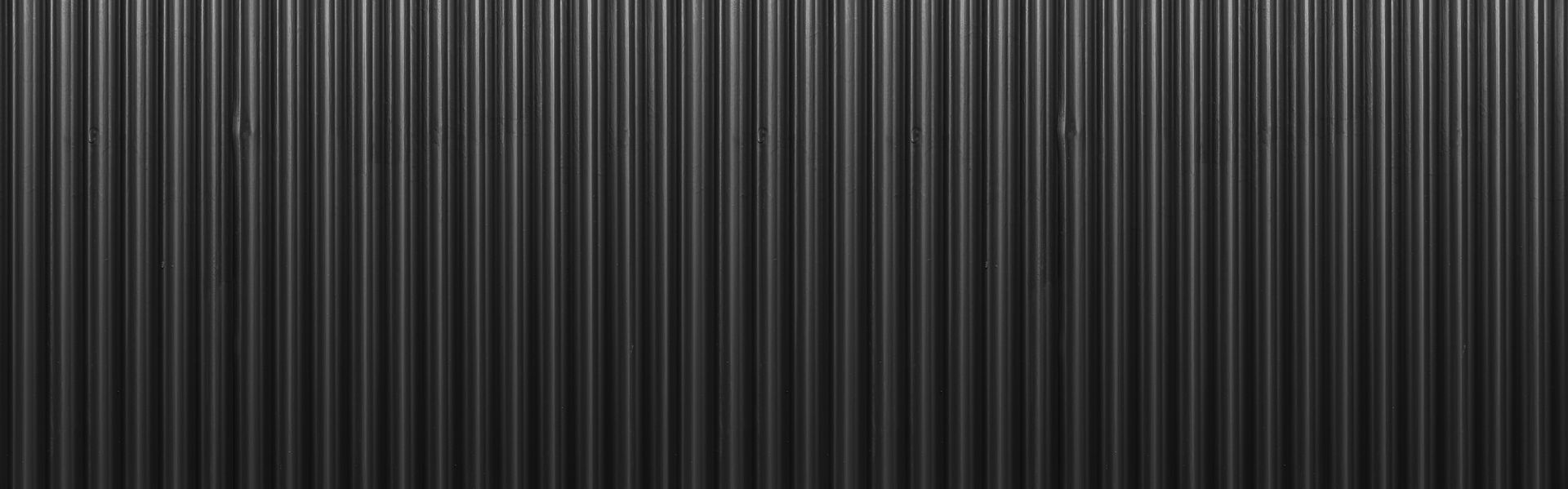 A close up of a black corrugated metal wall.