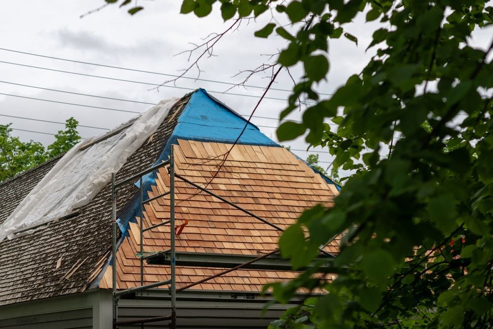 A roof undergoing a repair/replacement with Cedar Shake Roofing.