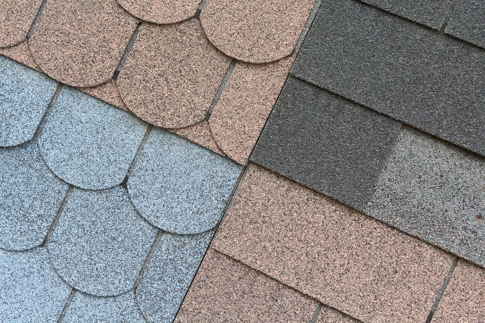 A close up of three different colored shingles on a roof.