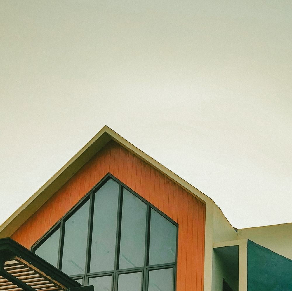 A house with a triangle shaped roof and a lot of windows