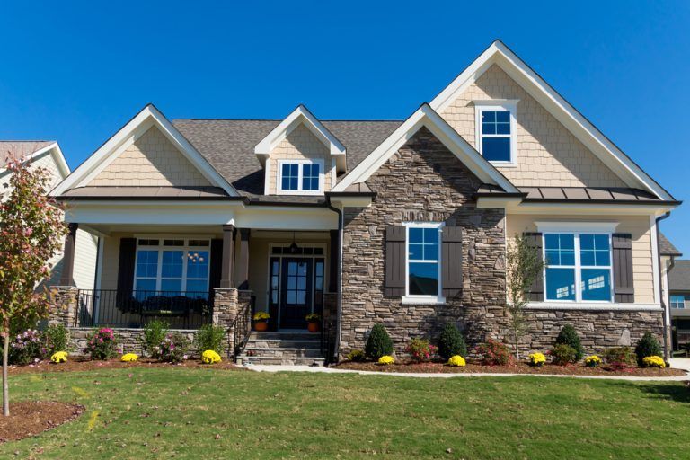 A large house with a lot of windows and a stone facade