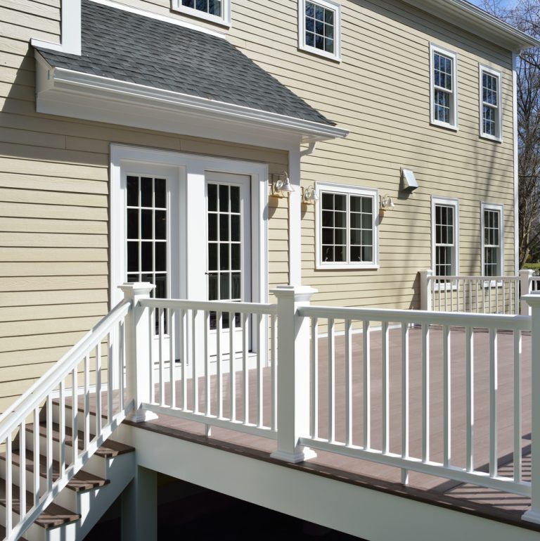 A house with a white railing and stairs leading up to it