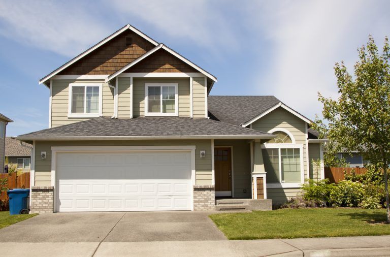 A house with a white garage door and a gray roof