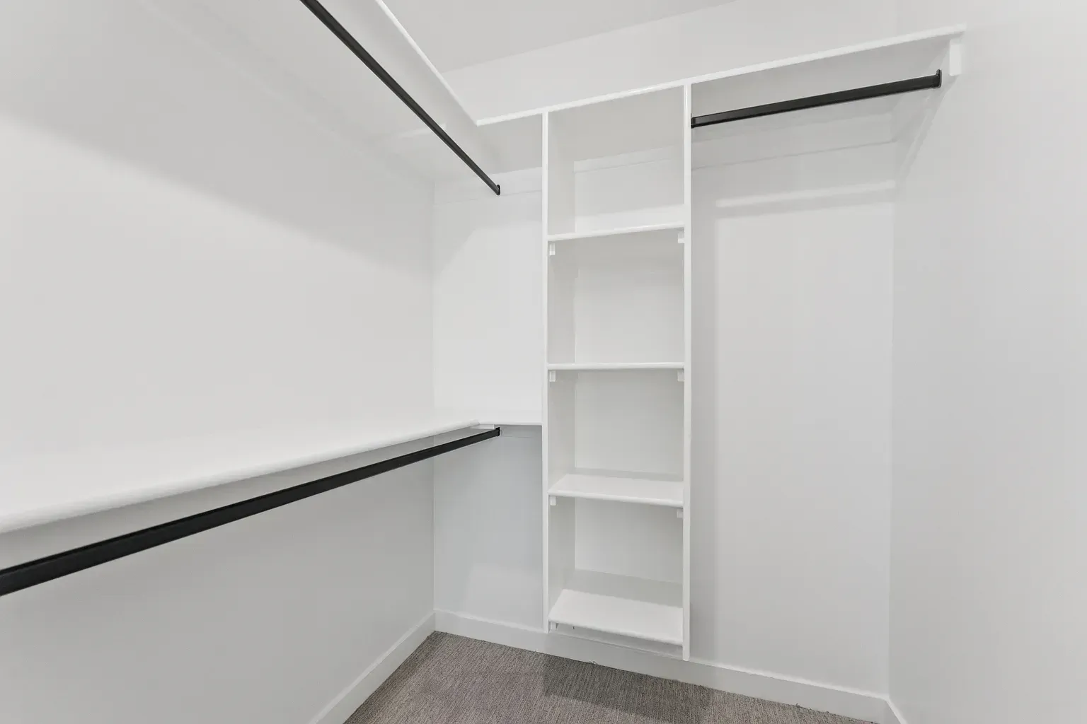 White walk-in closet with built-in shelves and hanging rods.
