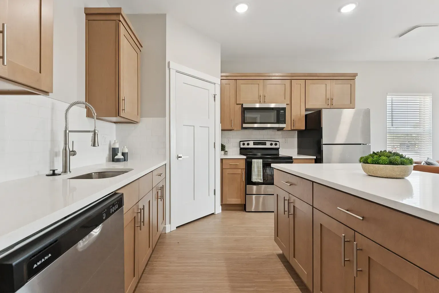 Modern kitchen with wood cabinets, stainless steel appliances, and a central island.