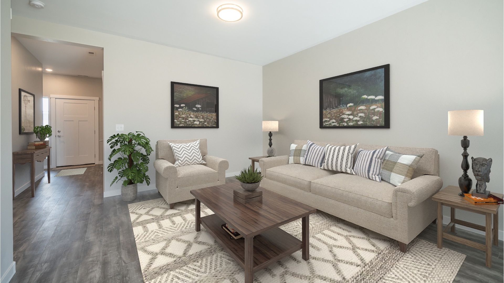 Living room in an apartment with beige sofa, two chairs, coffee table, and lamps.