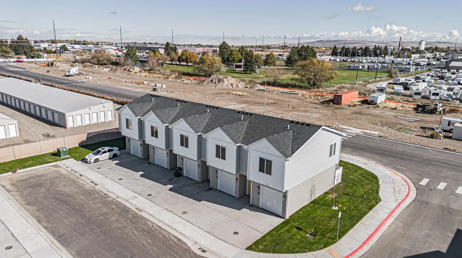 Aerial view of a row of townhouse-style apartment buildings with attached garages.
