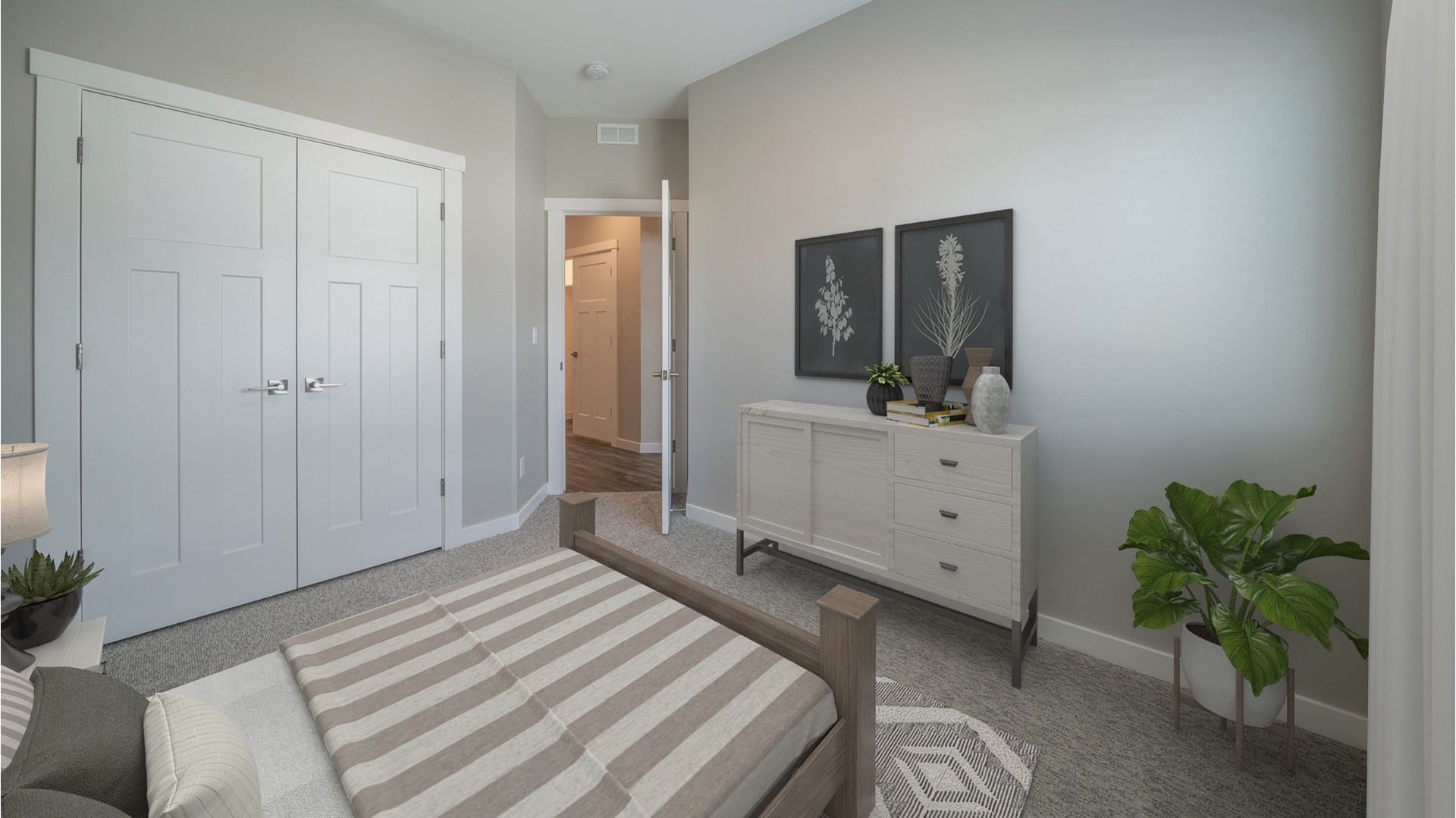 Bedroom with a wooden bed, white dresser, double closet doors, and a potted plant.