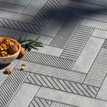 a bowl of nuts is sitting on an empire gray tile floor .