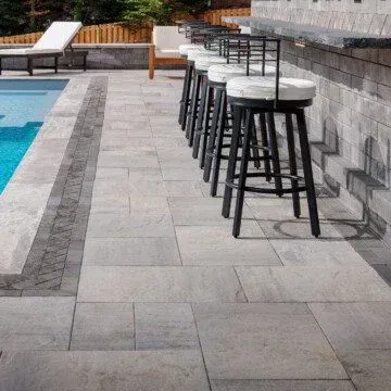 a row of bar stools are lined up next to a pool .