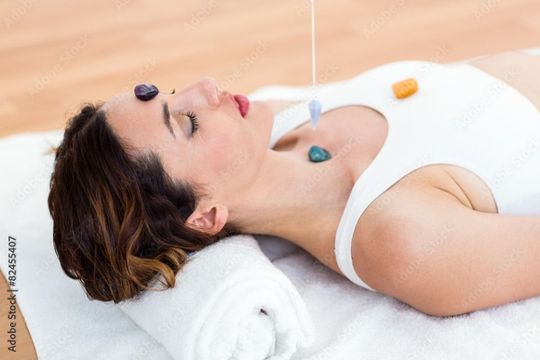 woman with stones on her body on wooden floor