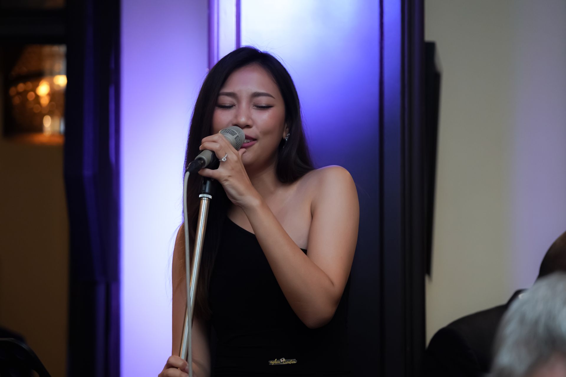 A woman is playing a violin in front of a microphone.