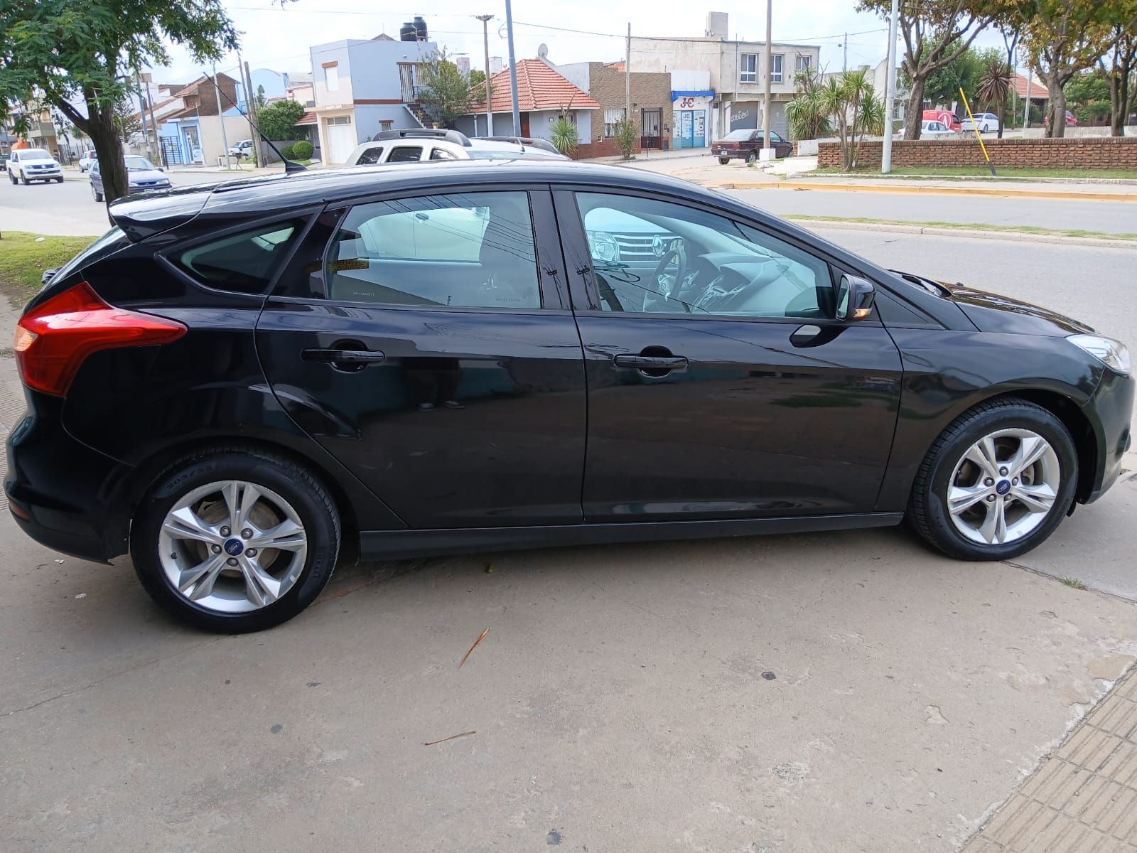 Ford Focus negro estacionado en una calle de la ciudad, día soleado.