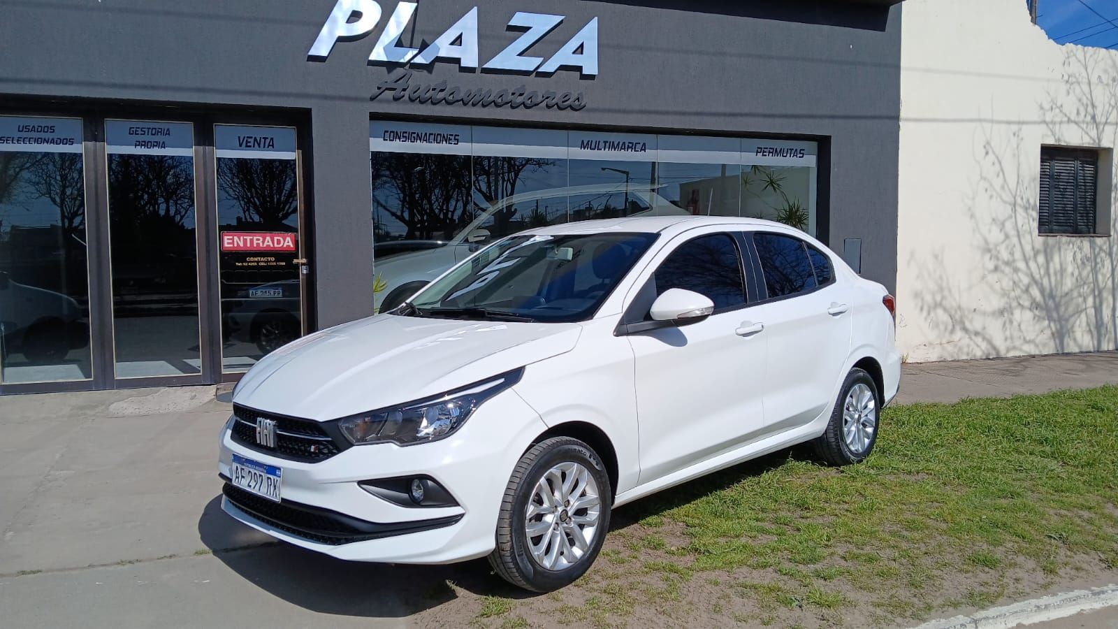 Fiat Cronos sedán blanco estacionado frente a un concesionario